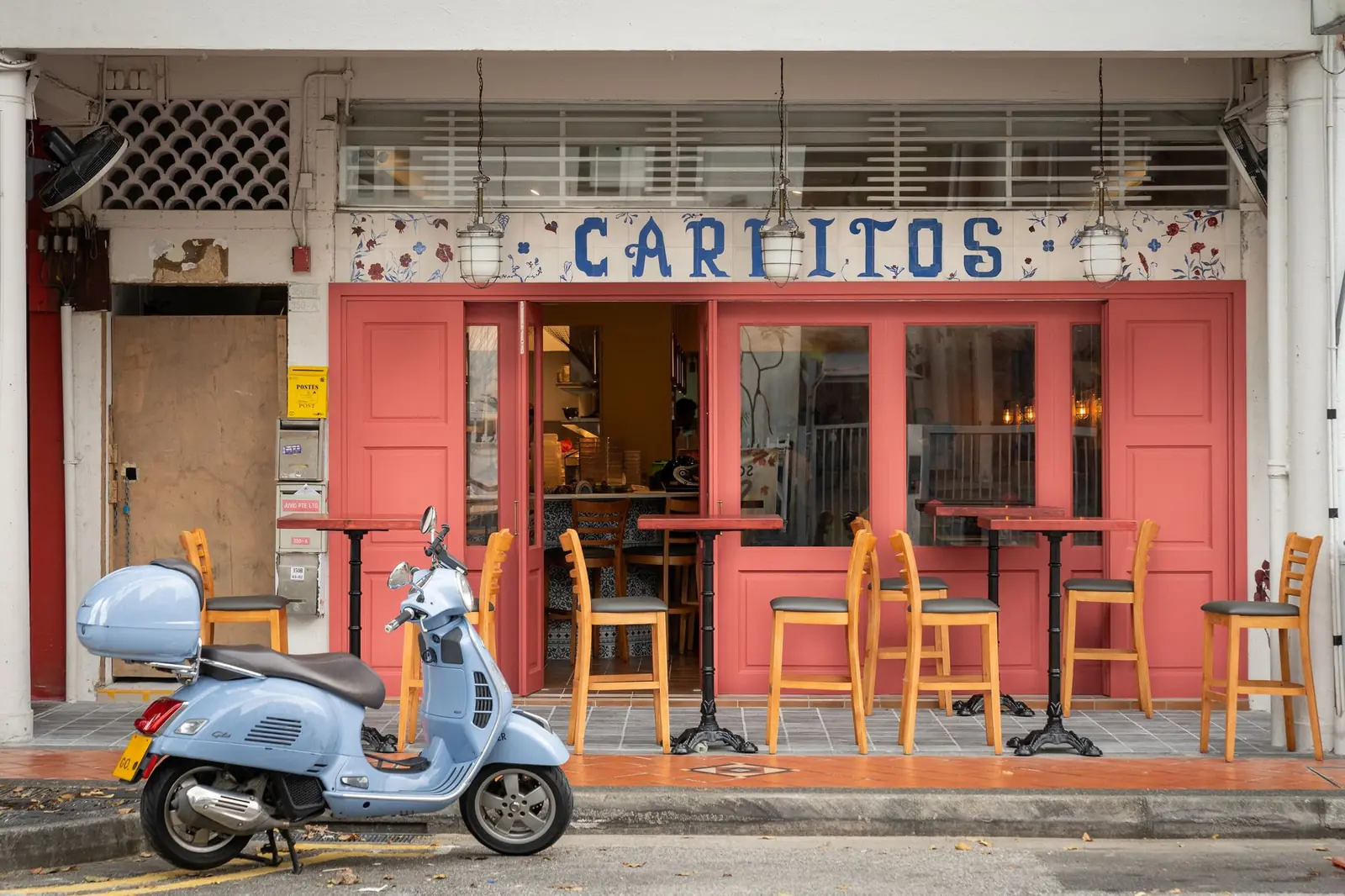 The shopfront of Carlitos, with a scooter parked outside