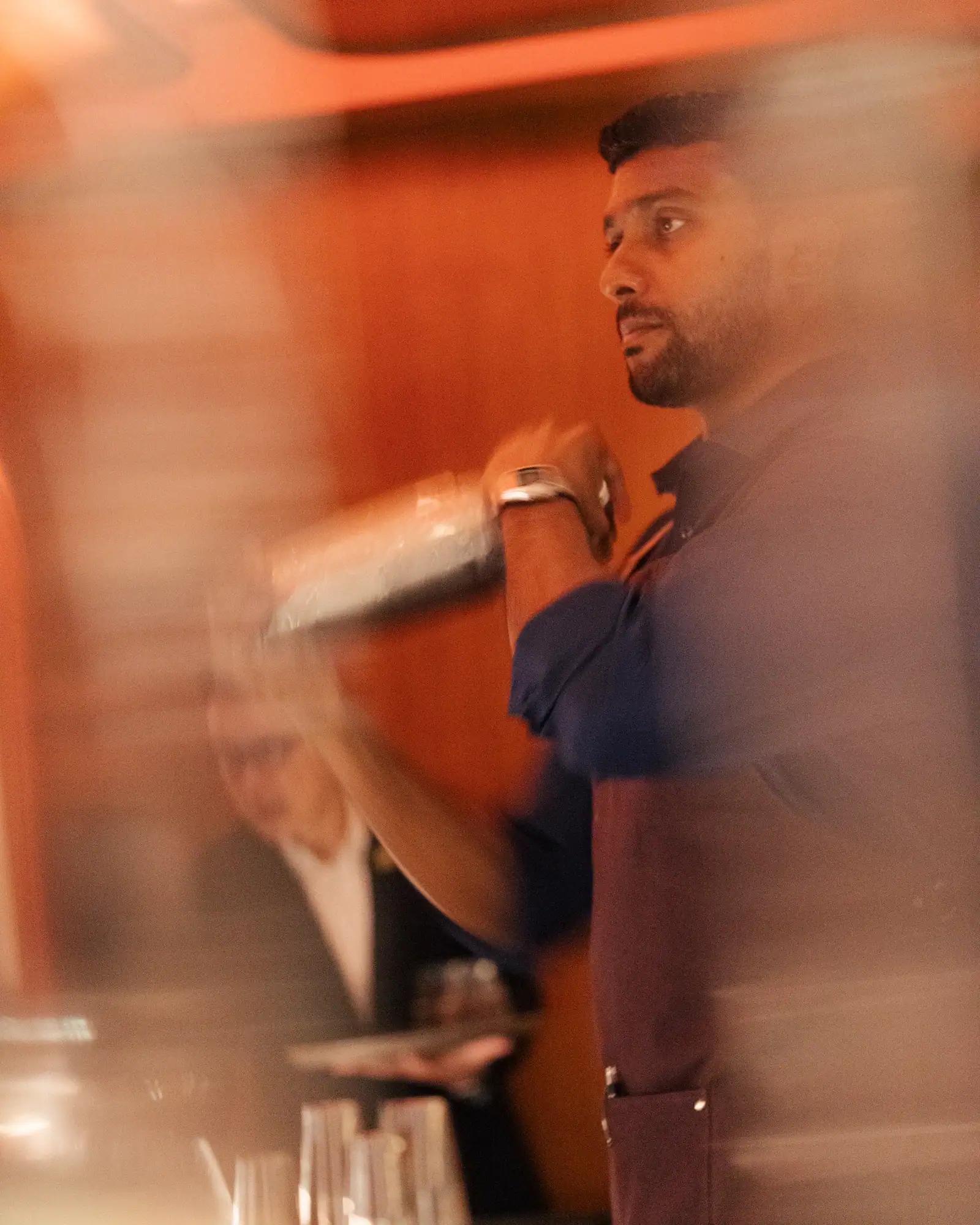 A bartender shaking a cocktail during service