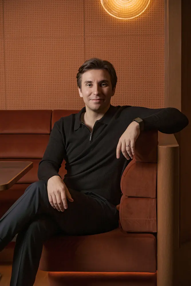 Philipp Hölke seated on a terracotta banquette